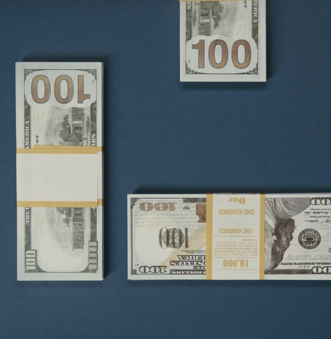 Bundles of $100 bills arranged neatly on a dark blue background