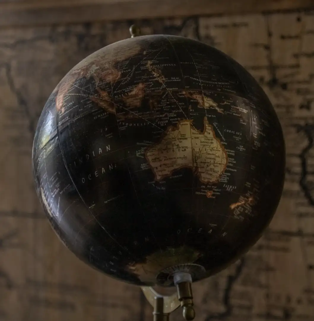 Close-up of a globe showing Australia, with the Indian Ocean labeled, against a map background.